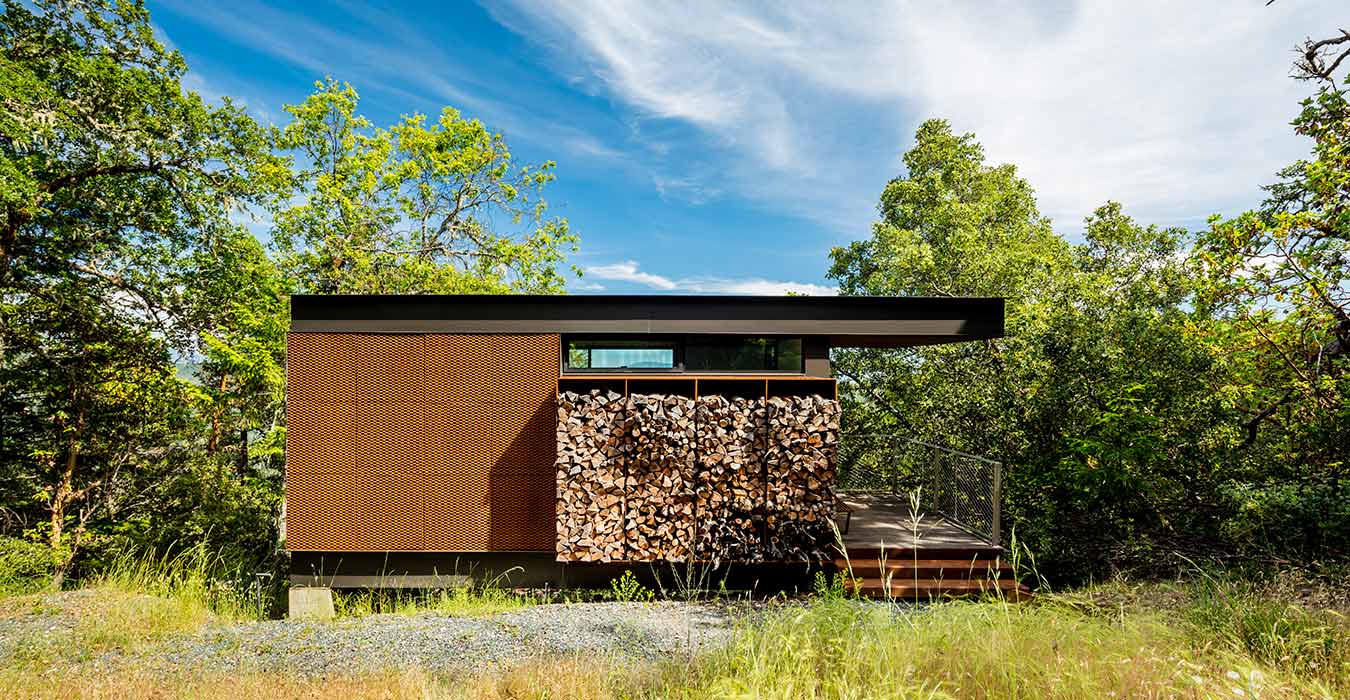 <p>Guest cabins share a the main house's material palette of reclaimed wood, cor-ten steel, floor-to-ceiling glass, and stacked firewood. <br><small>&copy;Tim Griffith</small></p>